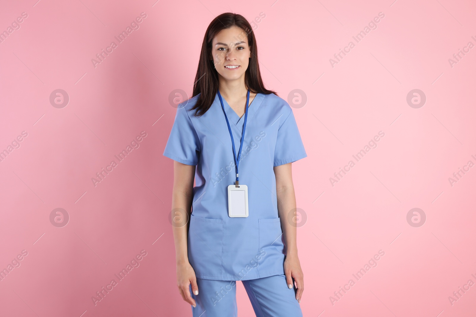 Photo of Smiling nurse with badge on pink background