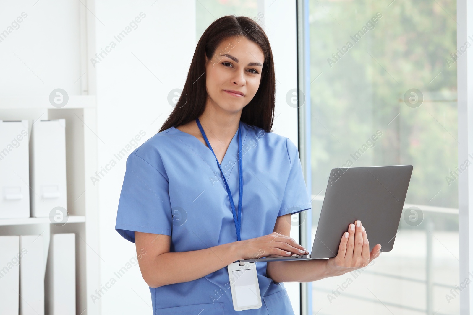 Photo of Beautiful nurse with laptop in hospital office