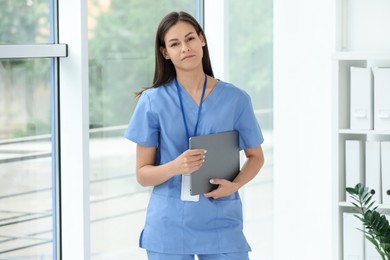 Beautiful nurse with laptop in hospital office