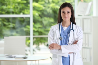 Photo of Beautiful nurse with crossed arms in hospital office. Space for text