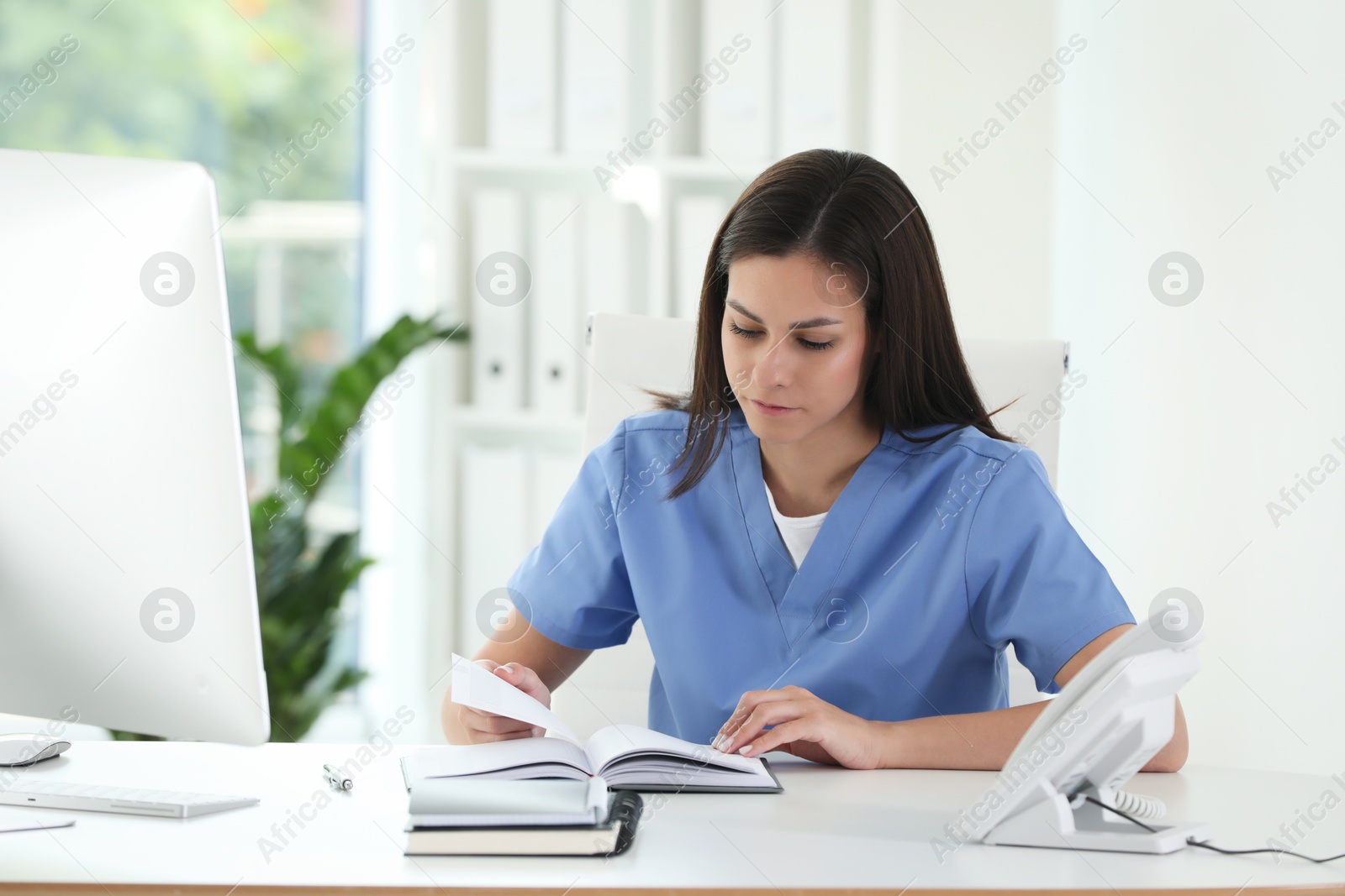 Photo of Beautiful nurse working at table in hospital office