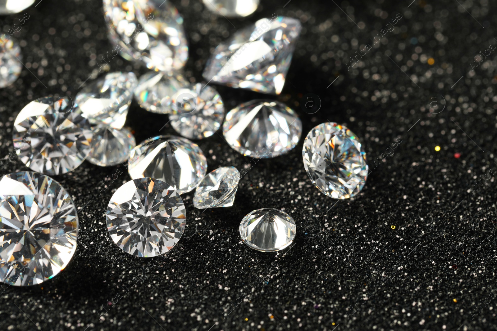 Photo of Beautiful dazzling diamonds on dark shiny background, closeup