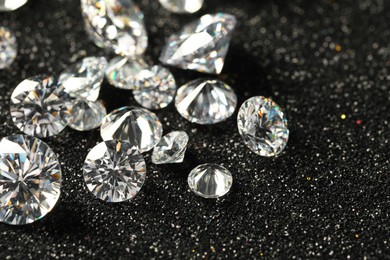 Photo of Beautiful dazzling diamonds on dark shiny background, closeup