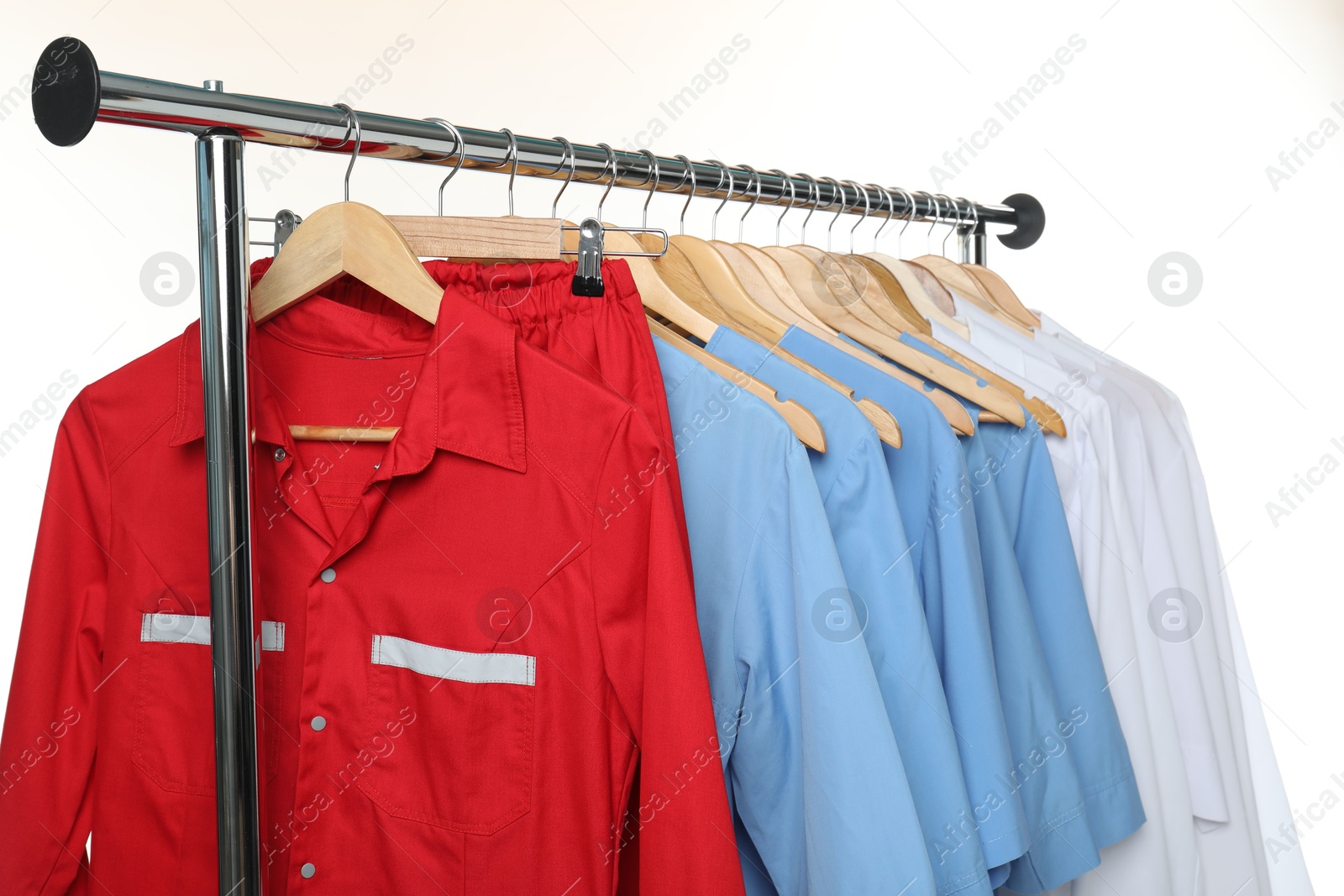 Photo of Different medical workers' uniforms on clothing rack against white background