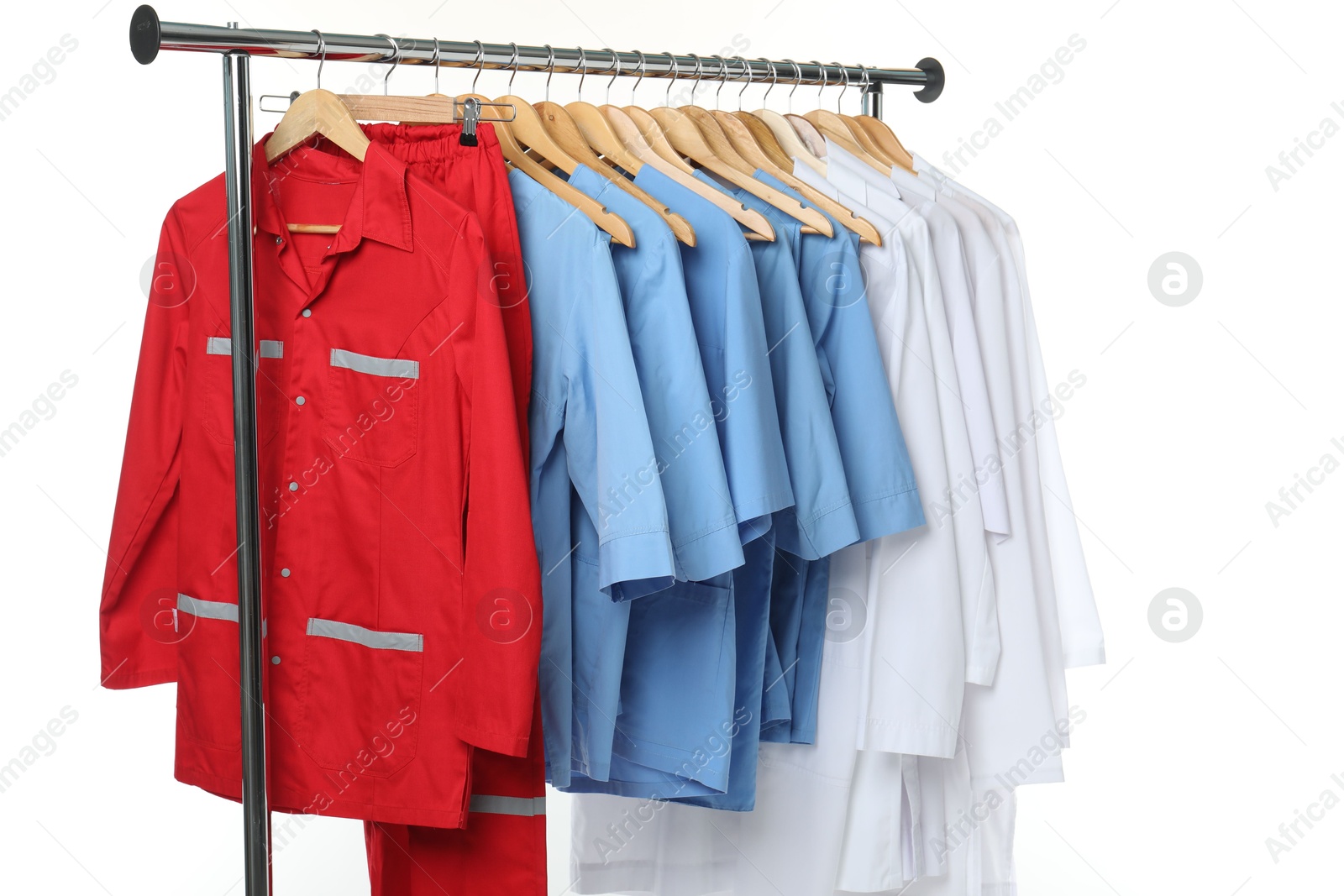 Photo of Different medical workers' uniforms on clothing rack against white background