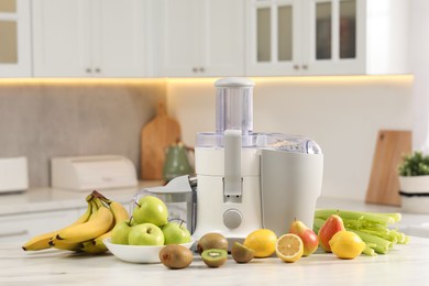 Modern juicer and fruits on white marble table in kitchen