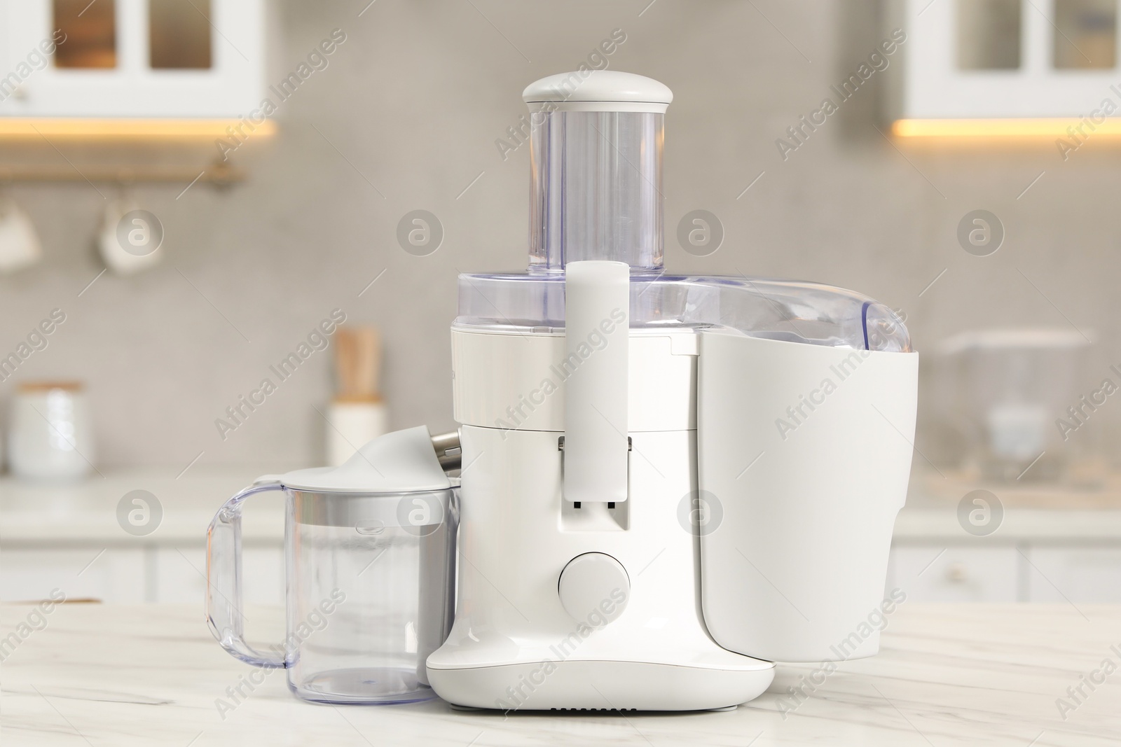 Photo of Modern juicer on white marble table in kitchen