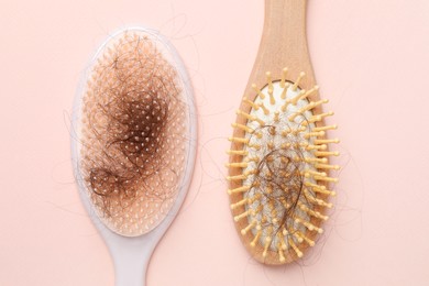 Brushes with lost hair on light pink background, flat lay