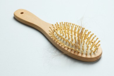 Photo of One brush with lost hair on grey background. Alopecia problem