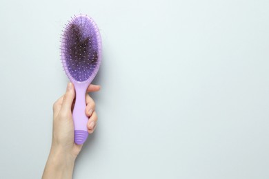 Photo of Woman with brush and lost hair on grey background, top view. Space for text