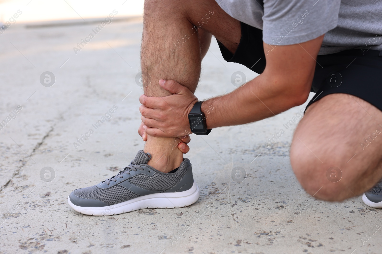 Photo of Man suffering from foot pain outdoors, closeup