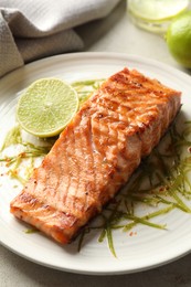 Delicious grilled salmon fillet served on light table, closeup