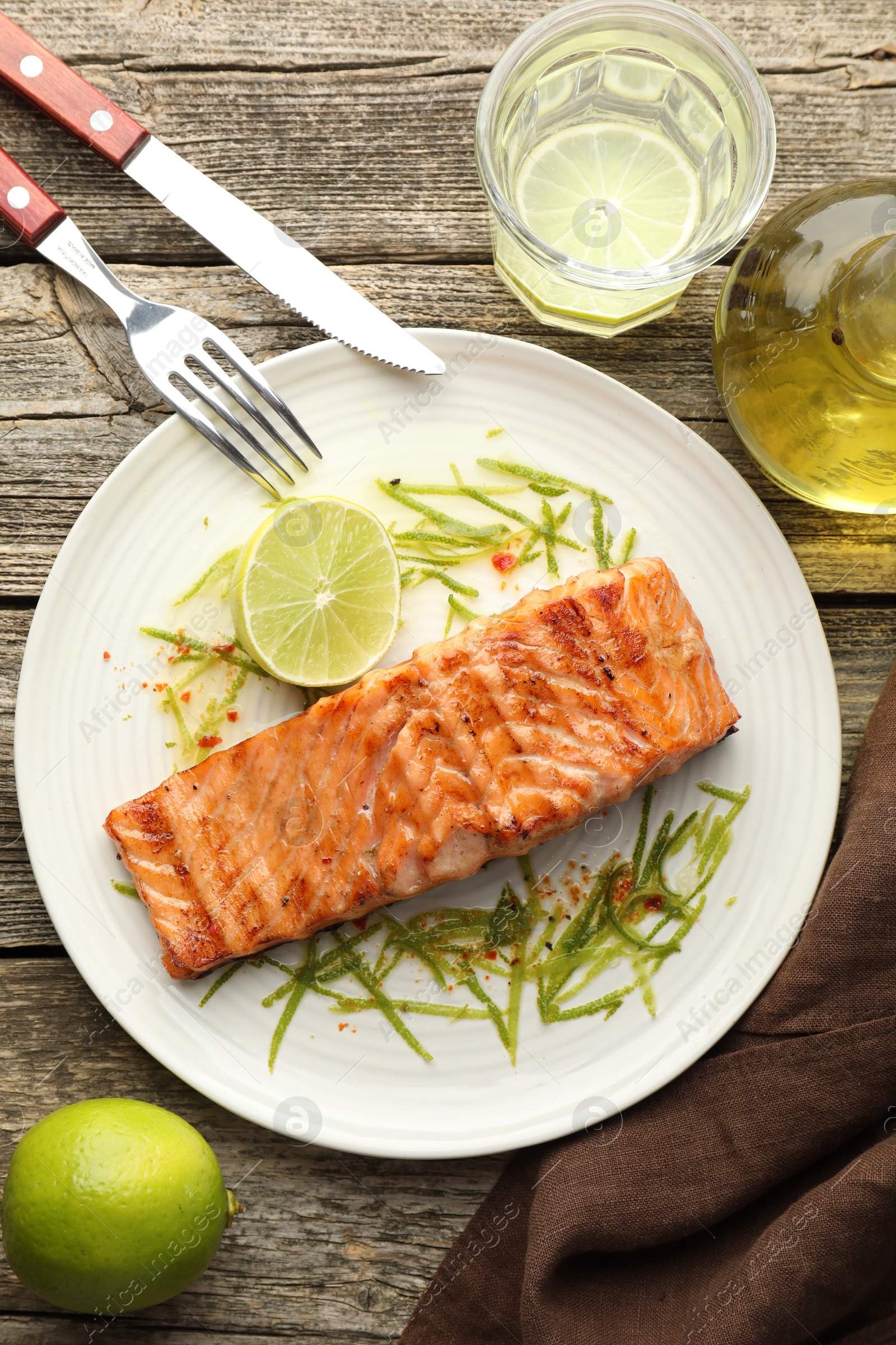 Photo of Delicious grilled salmon fillet served on wooden table, flat lay