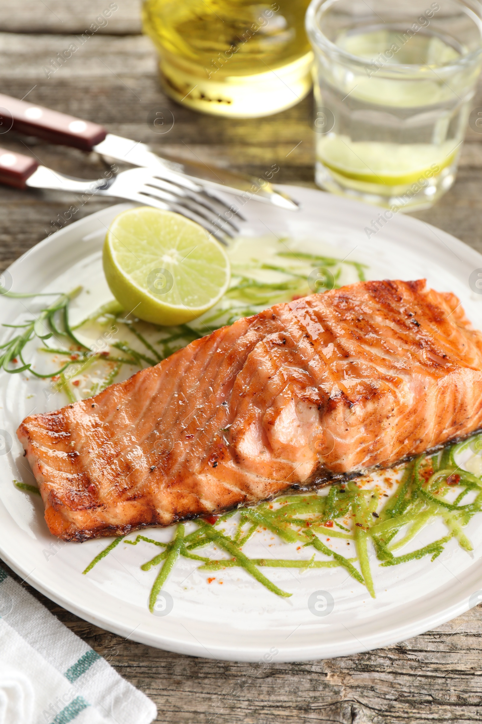 Photo of Delicious grilled salmon fillet served on wooden table, closeup