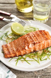 Delicious grilled salmon fillet served on wooden table, closeup