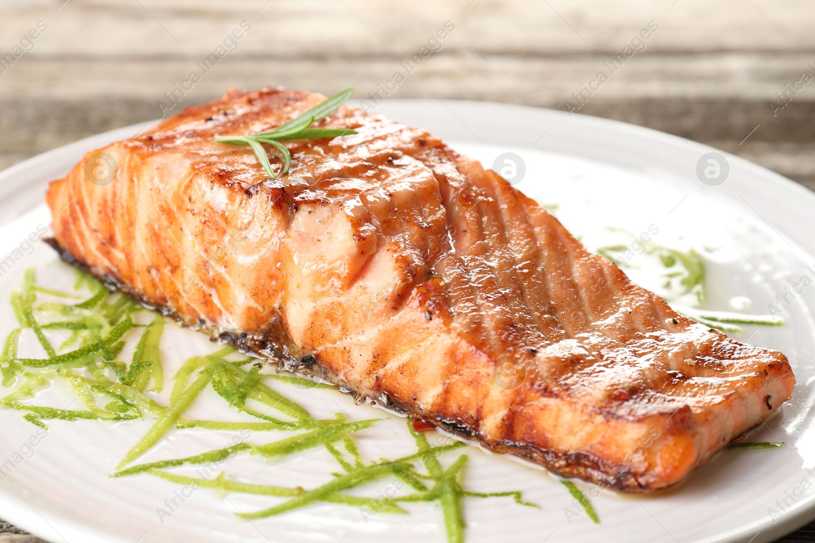 Photo of Delicious grilled salmon fillet served on table, closeup