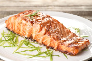 Photo of Delicious grilled salmon fillet served on table, closeup