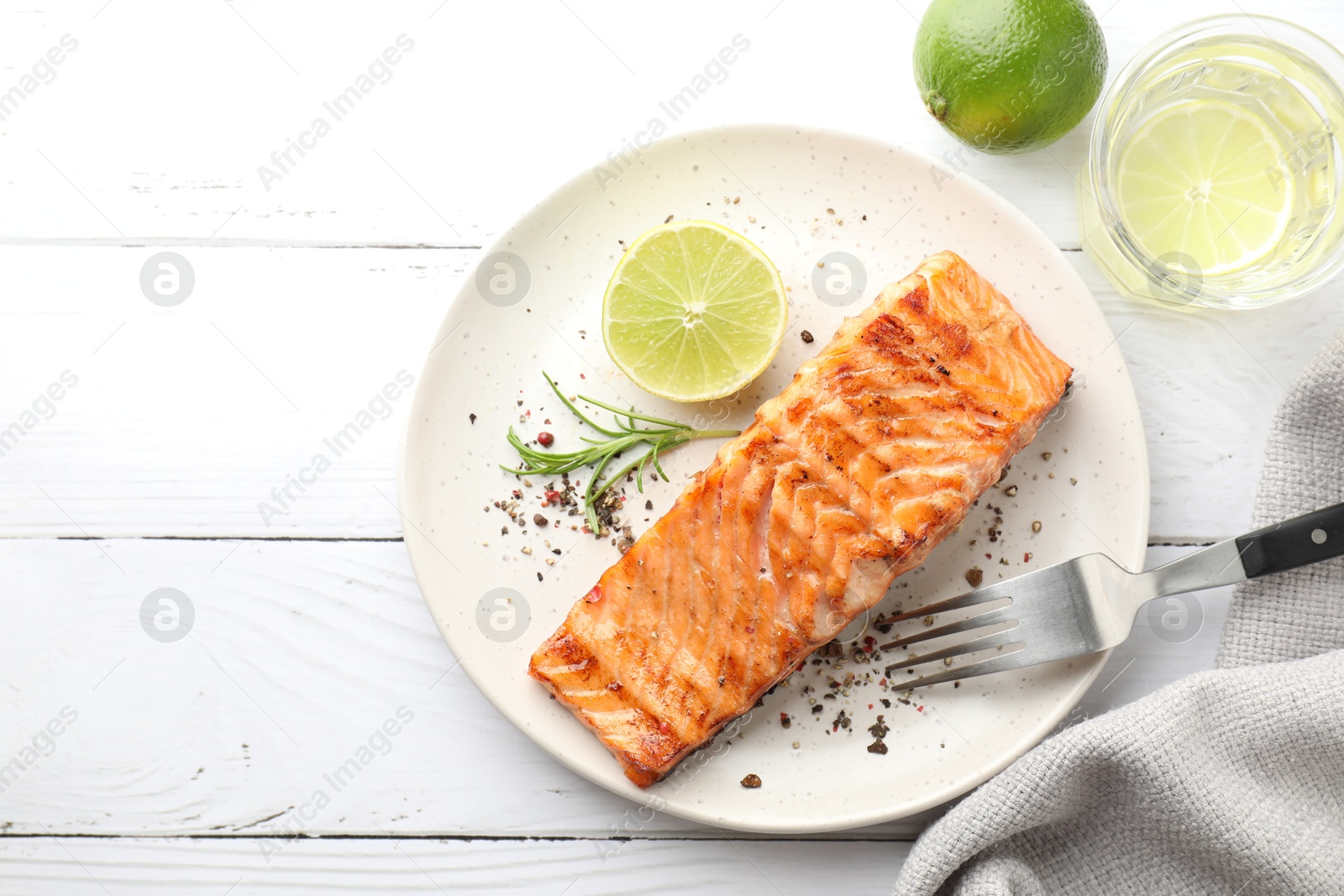 Photo of Delicious grilled salmon fillet served on white wooden table, flat lay