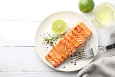 Delicious grilled salmon fillet served on white wooden table, flat lay