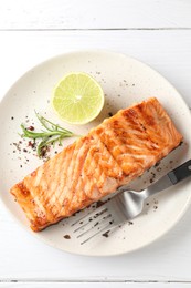 Photo of Delicious grilled salmon fillet served on white wooden table, top view