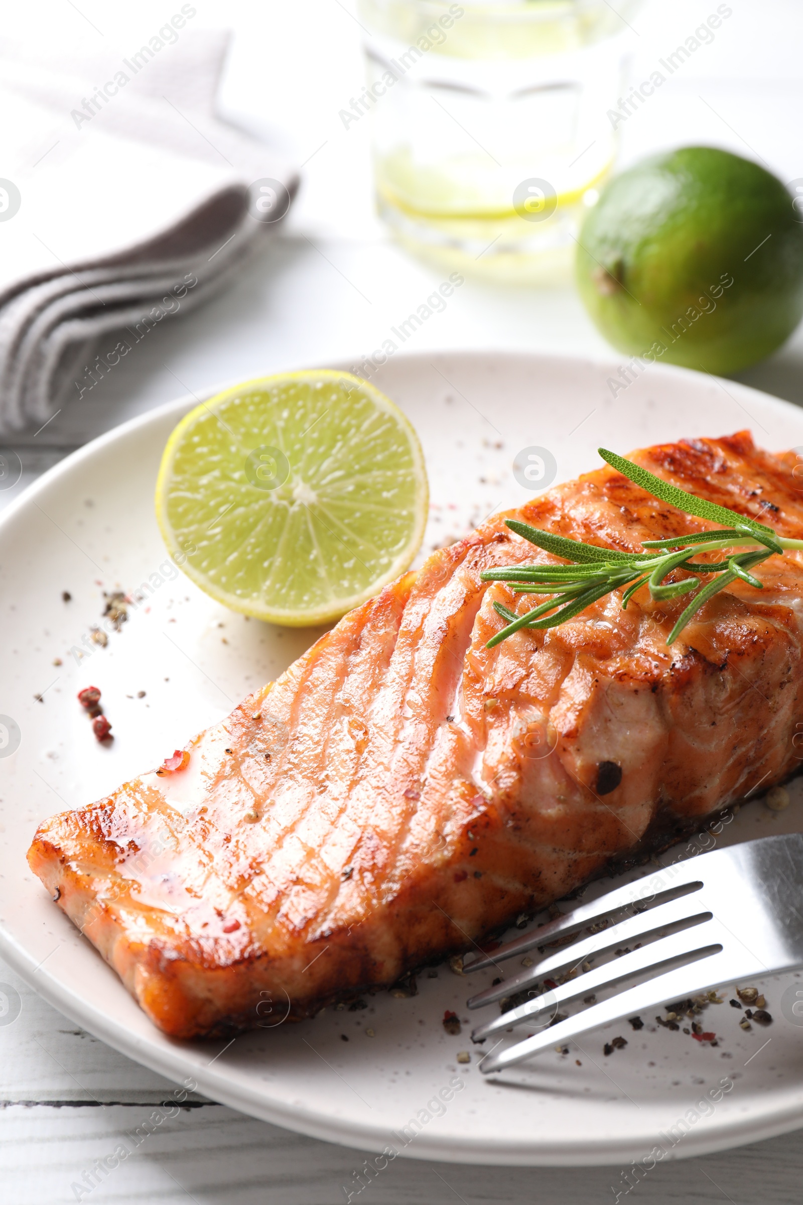 Photo of Delicious grilled salmon fillet served on white wooden table, closeup