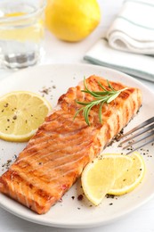 Delicious grilled salmon fillet served on white table, closeup