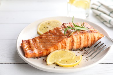 Delicious grilled salmon fillet served on white wooden table, closeup