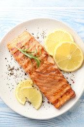 Delicious grilled salmon fillet served on light blue wooden table, top view