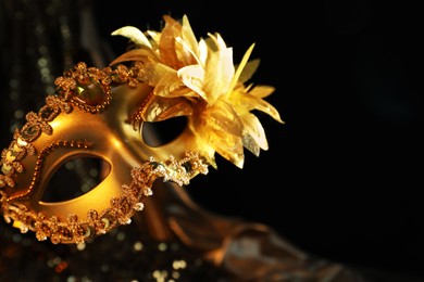 Beautiful golden carnival mask in darkness, closeup