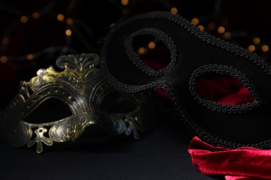 Beautiful carnival mask on black background against blurred lights, closeup