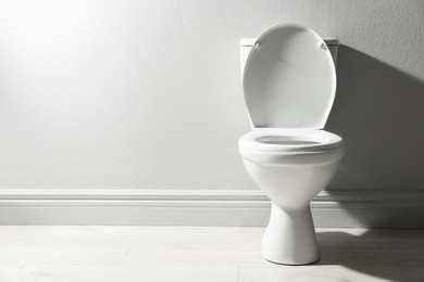 Photo of One toilet bowl near white wall indoors, space for text