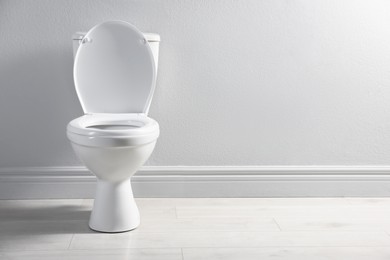 Photo of One toilet bowl near white wall indoors, space for text