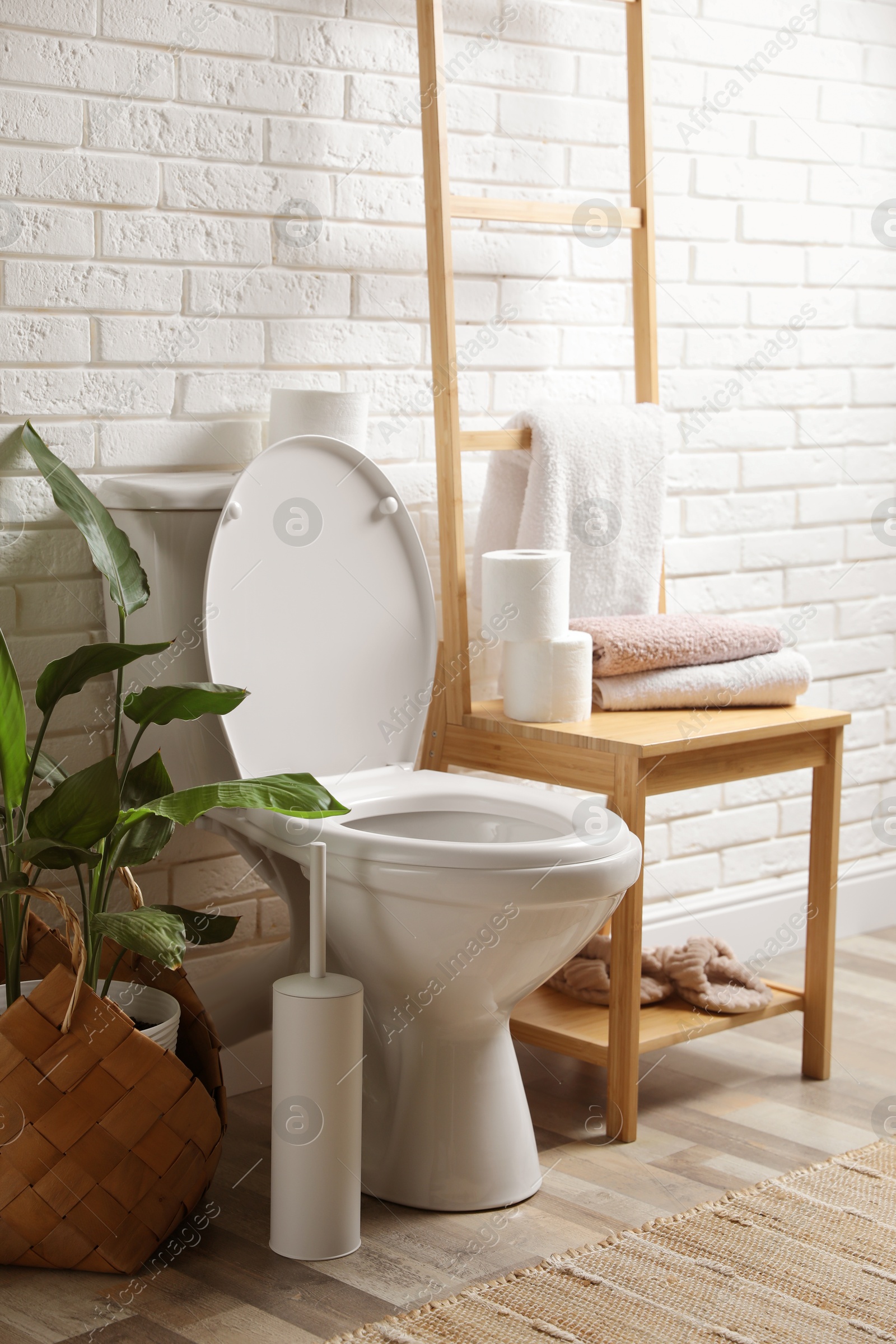 Photo of Ceramic toilet bowl and necessities in restroom