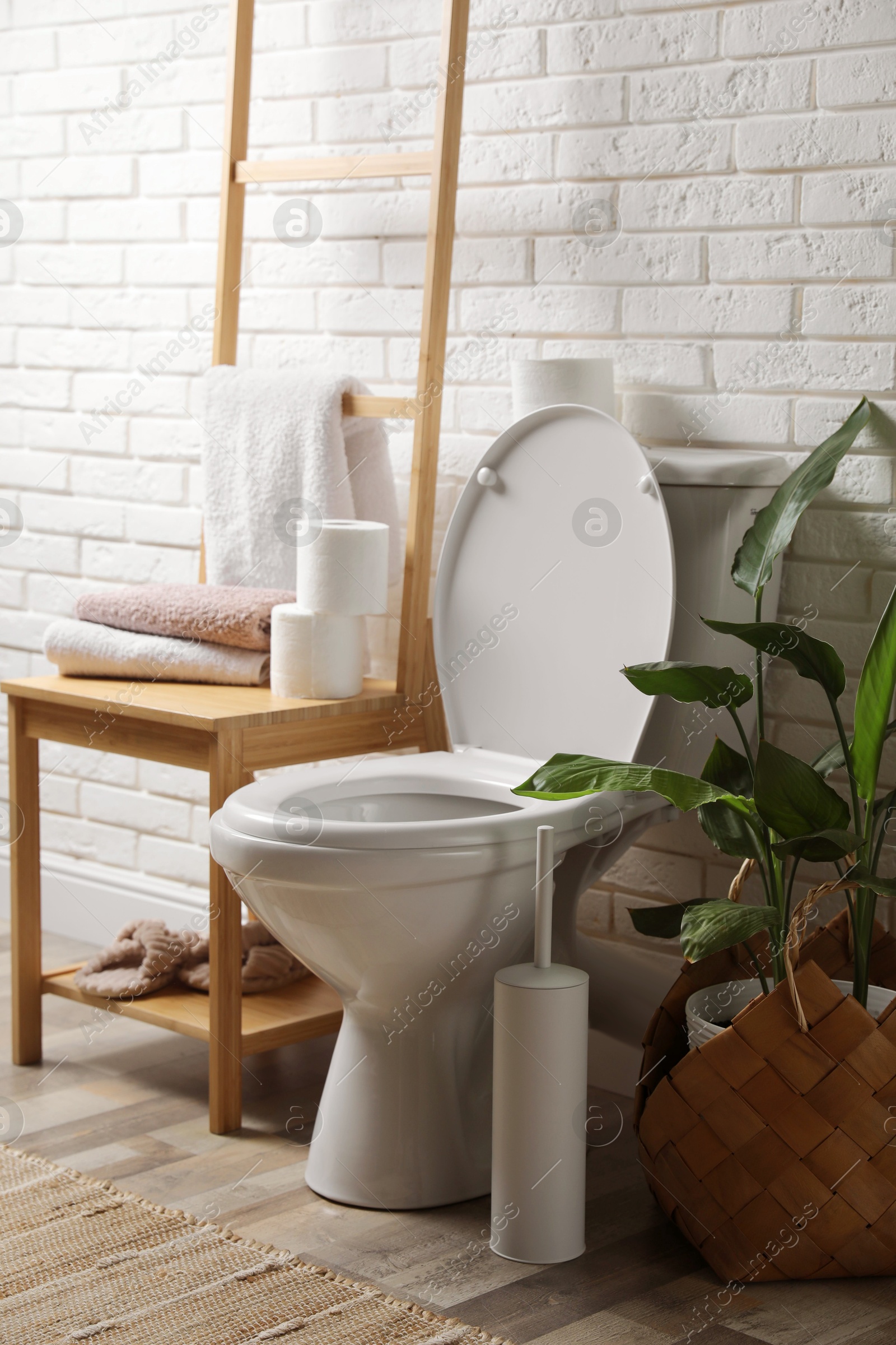 Photo of Ceramic toilet bowl and necessities in restroom