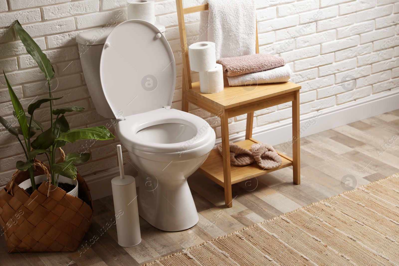 Photo of Ceramic toilet bowl and necessities in restroom