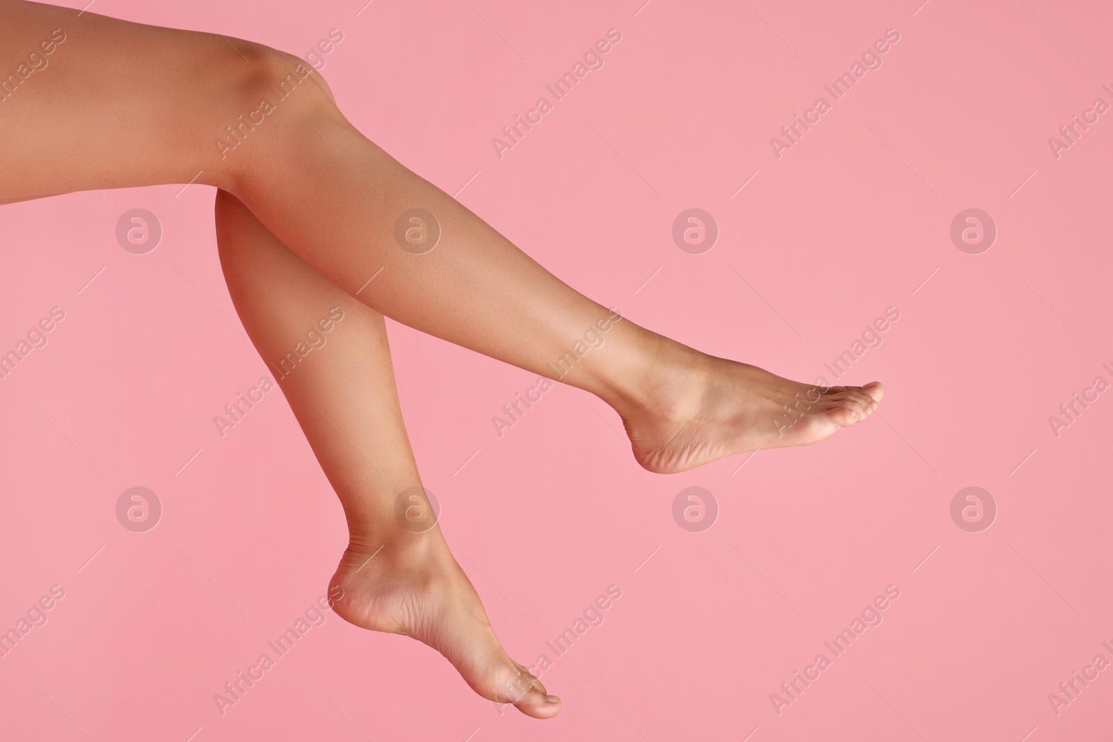 Photo of Woman with smooth legs on pink background, closeup