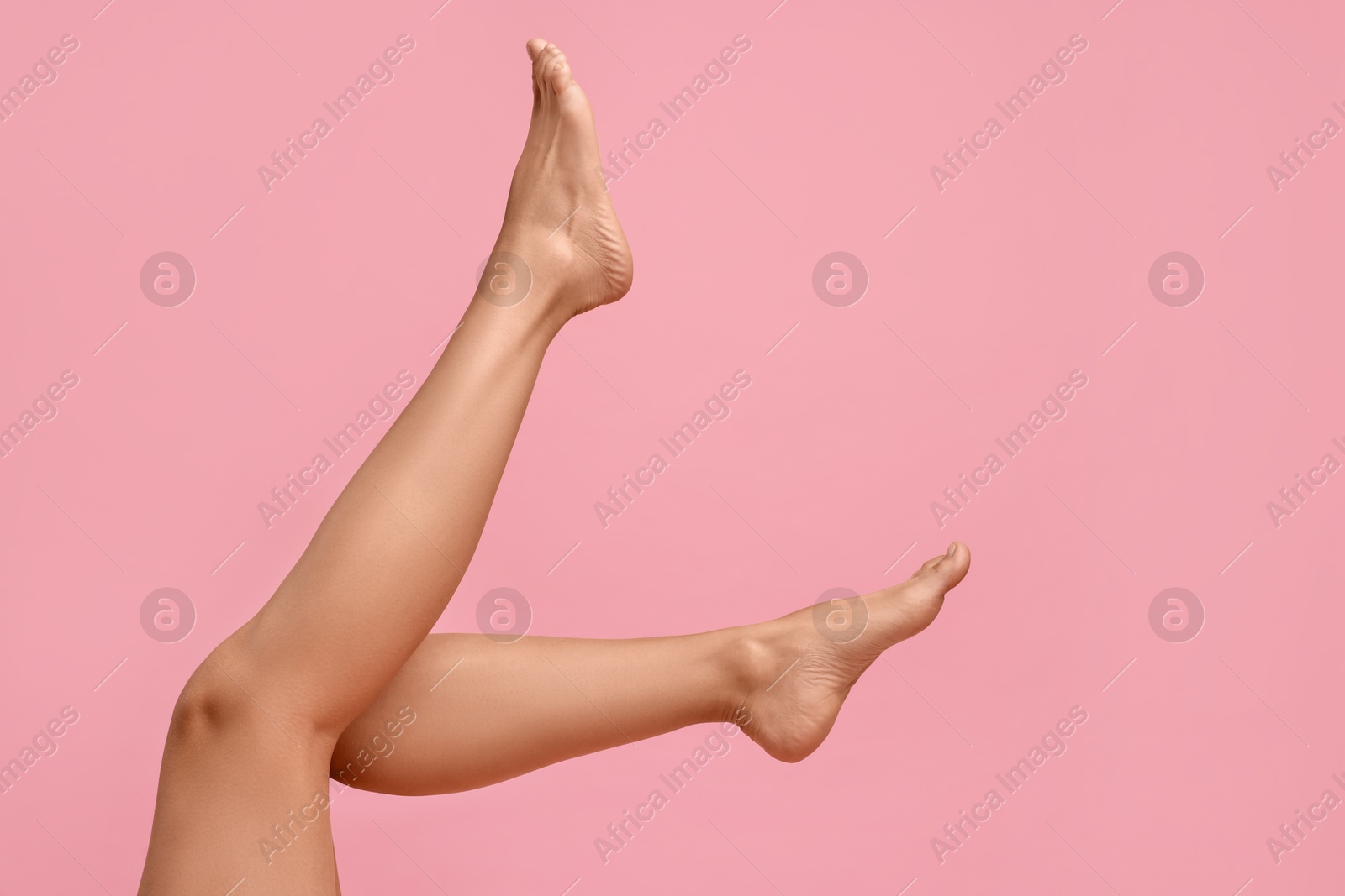 Photo of Woman with smooth legs on pink background, closeup