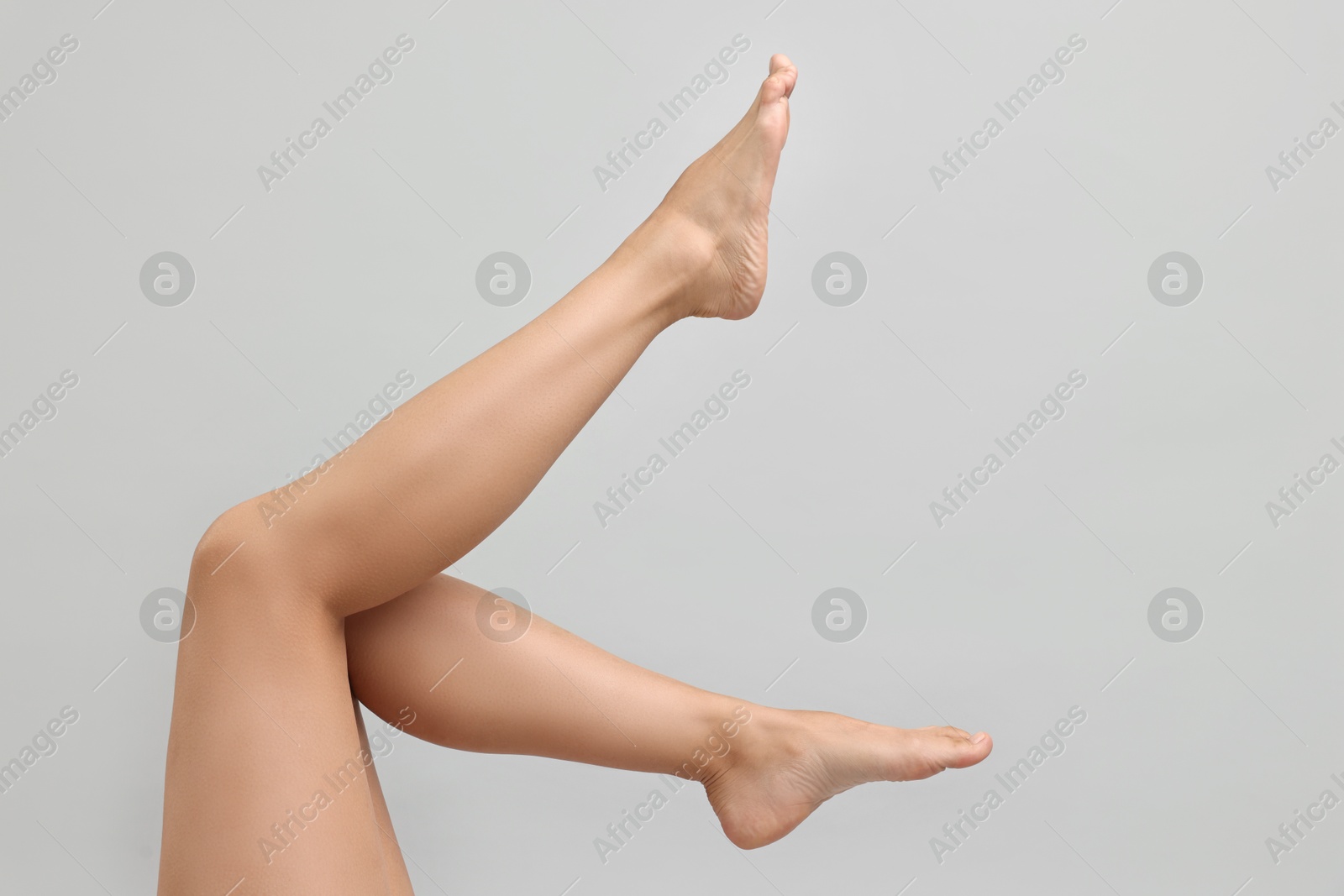 Photo of Woman with smooth legs on grey background, closeup. Space for text