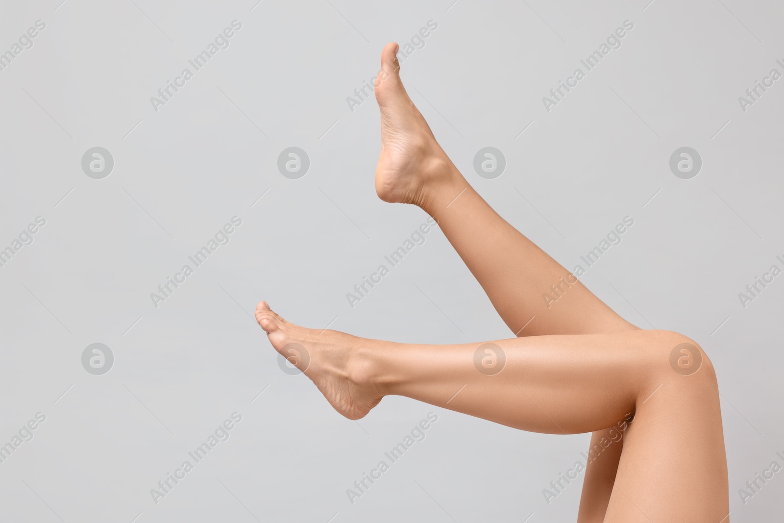 Photo of Woman with smooth legs on grey background, closeup. Space for text