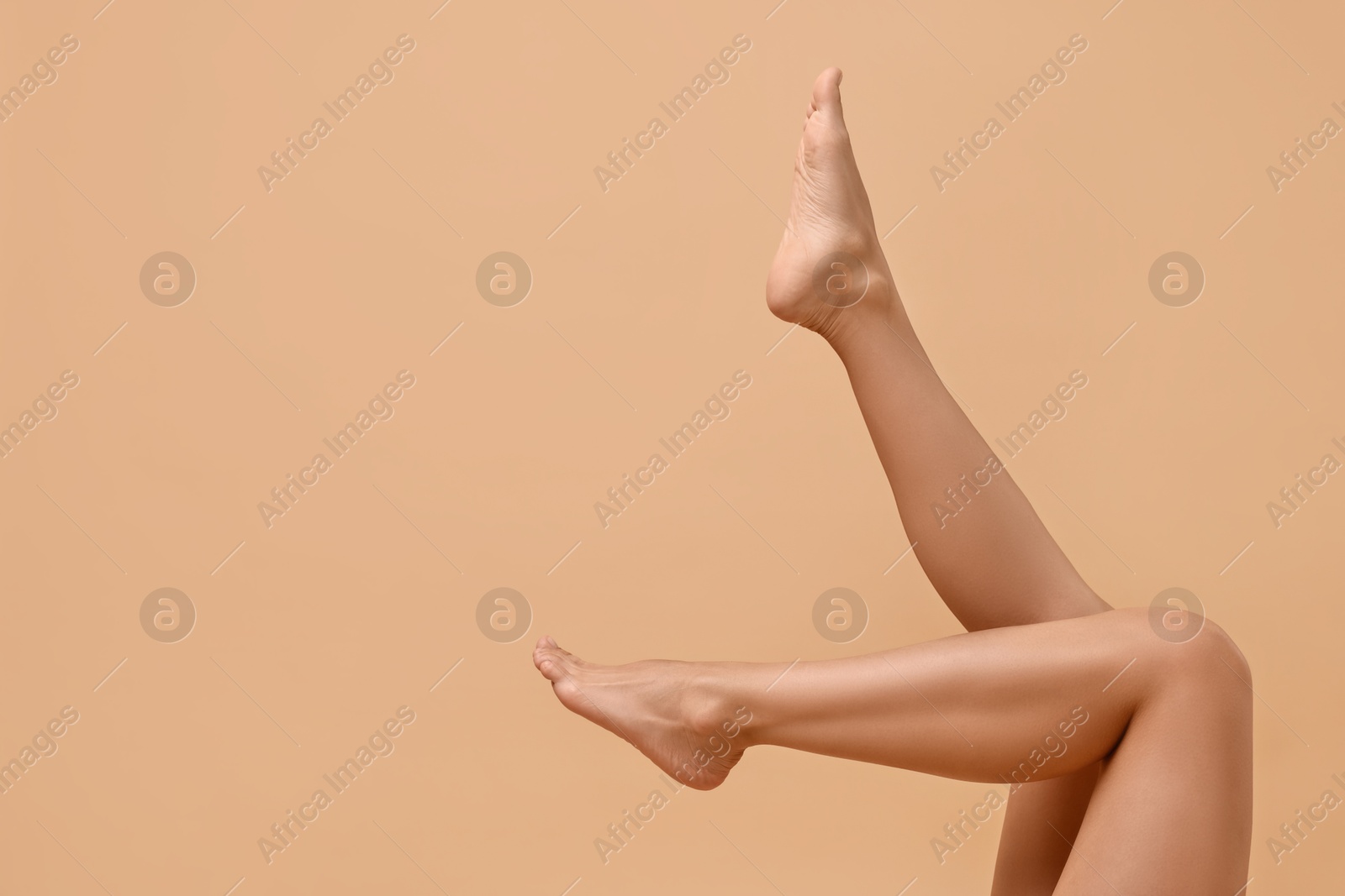 Photo of Woman with smooth legs on beige background, closeup. Space for text