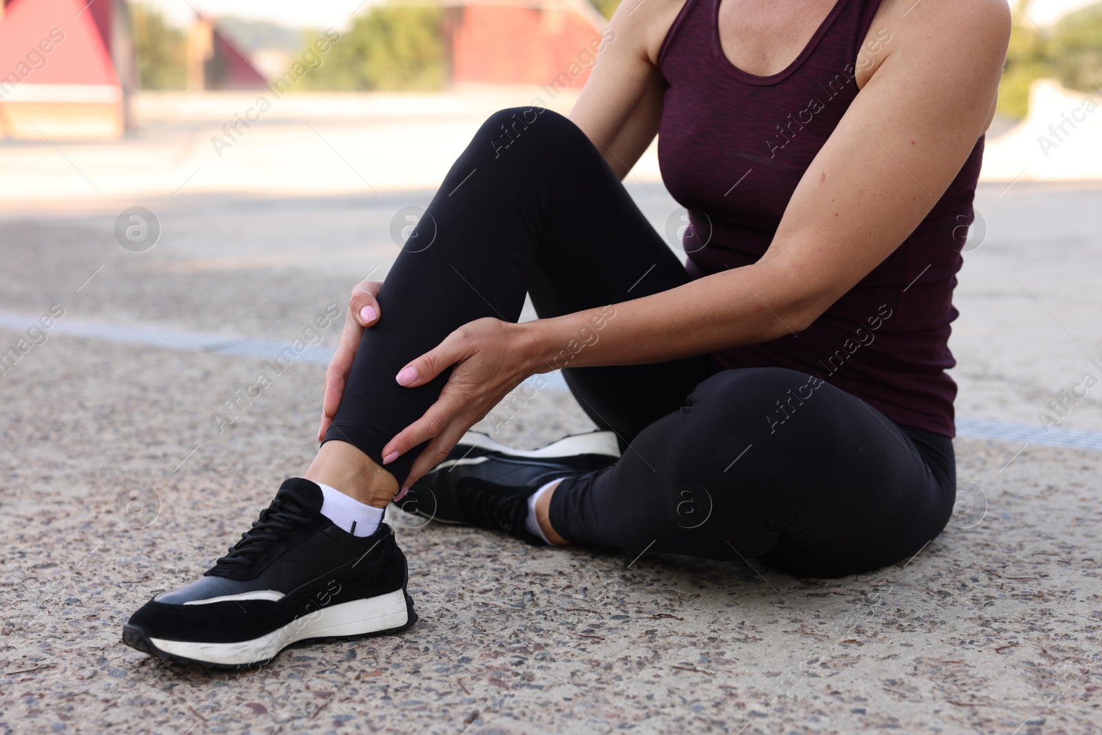 Photo of Woman suffering from foot pain outdoors, closeup