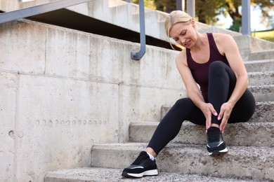 Woman suffering from foot pain on steps