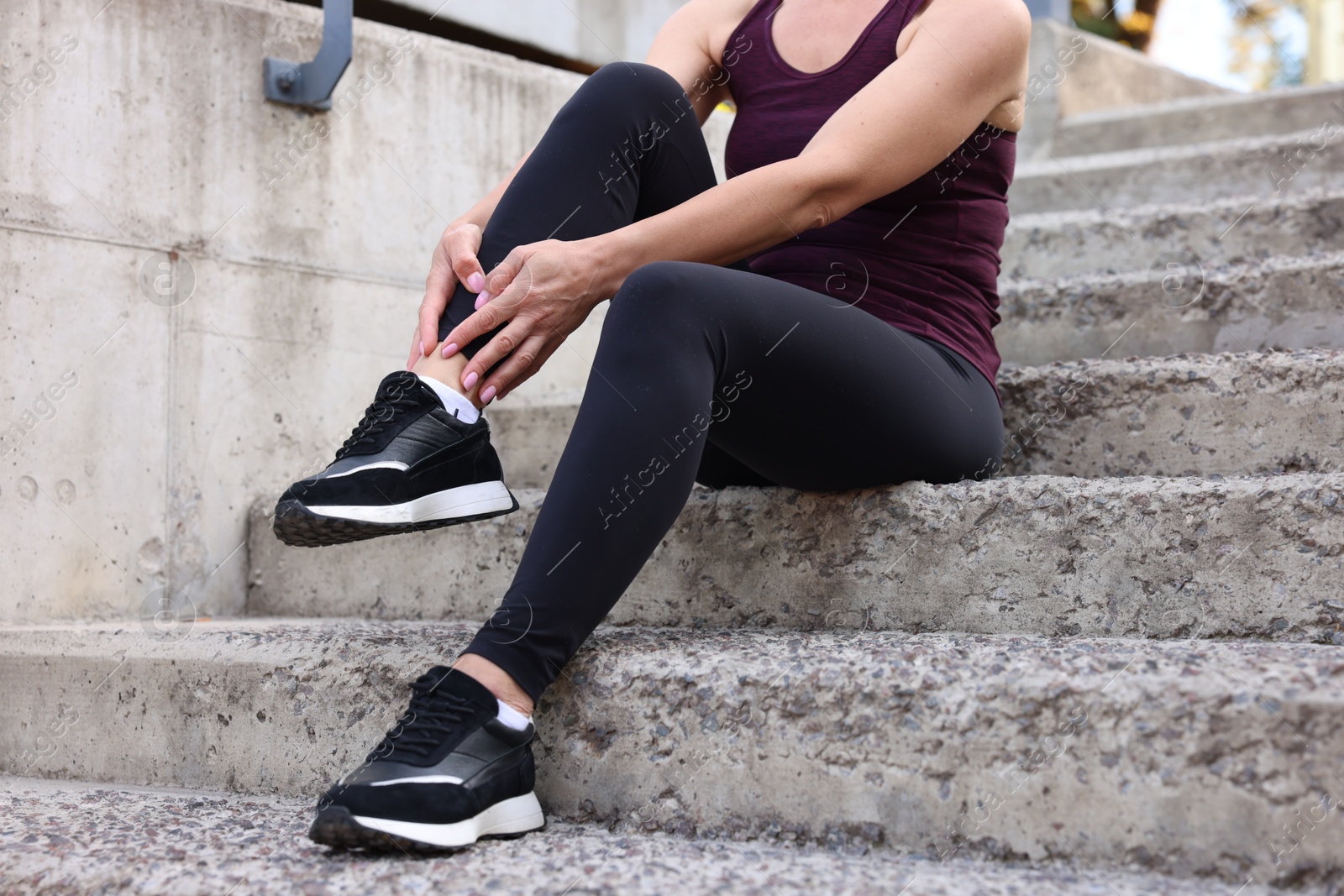 Photo of Woman suffering from foot pain on steps, closeup