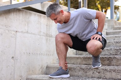 Man suffering from foot pain on steps