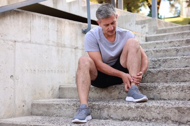 Photo of Man suffering from foot pain on steps