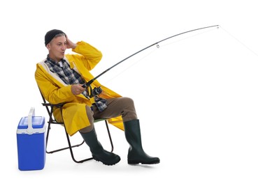 Emotional fisherman with rod on fishing chair near cooler box against white background