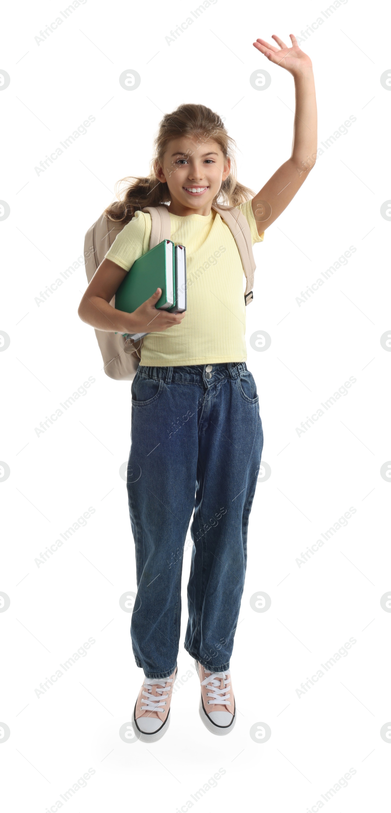 Photo of Girl with backpack and books jumping on white background