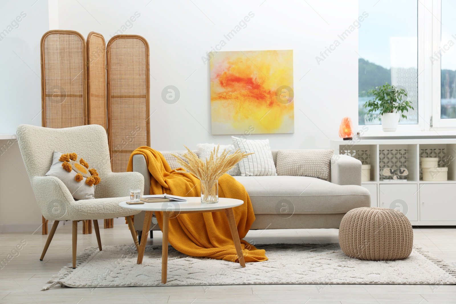 Photo of Comfortable sofa, armchair, coffee table and folding screen in living room