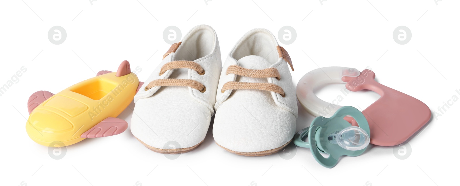 Photo of Colorful rattles, baby shoes and pacifier isolated on white