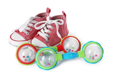 Colorful rattle and baby shoes isolated on white